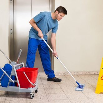 Happy Male Janitor With Cleaning Equipments Mopping Floor